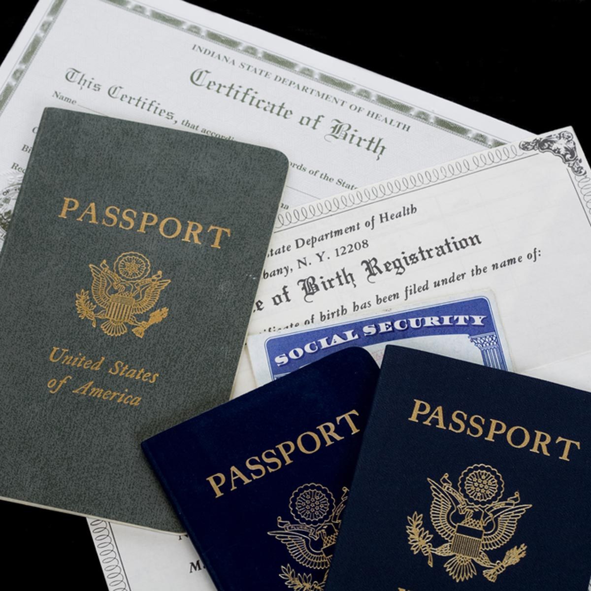 Multiple passports and important documents are arranged on a surface, indicating personal identification and citizenship information amidst a neutral background.