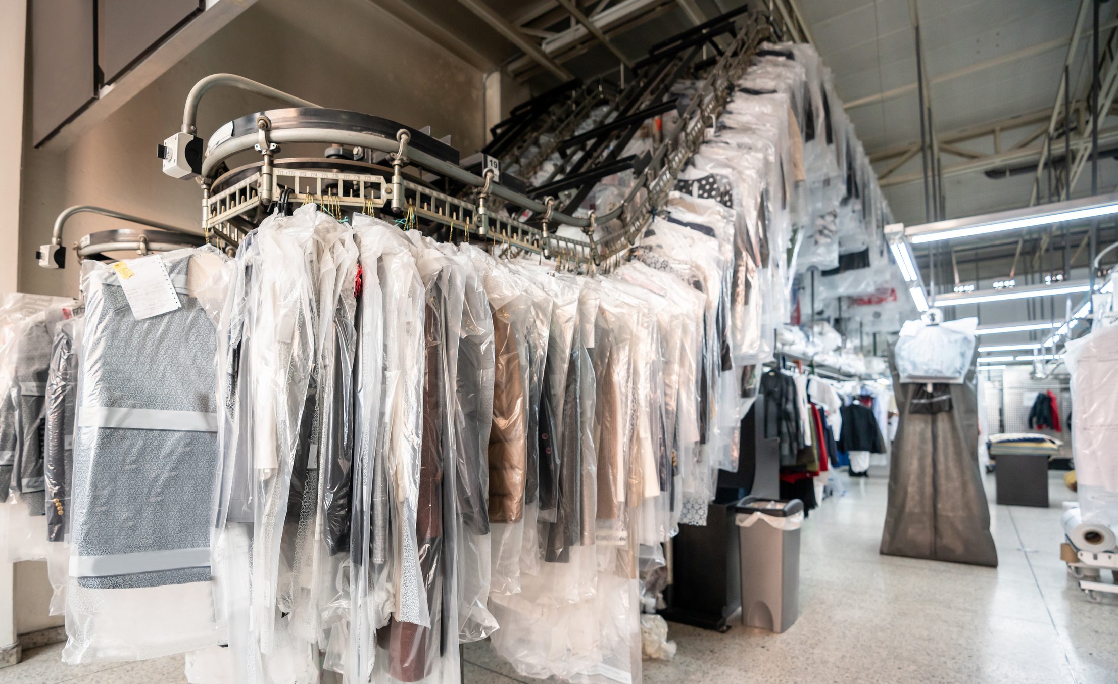 Industrial dry cleaning warehouse with conveyor belt full of clothes
