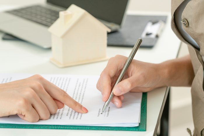 Client Signs Document to Buy House and Real Estate
